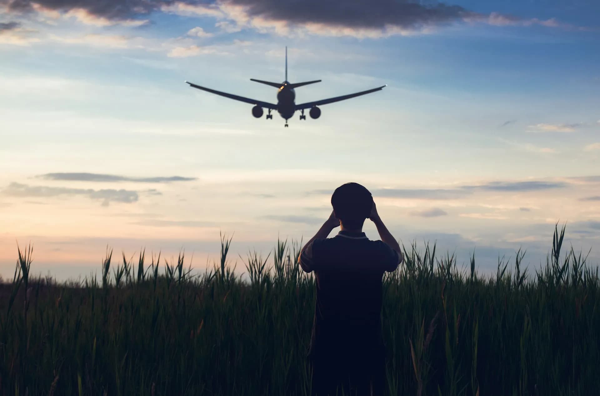 Traveller watching a plane take off from the terminal